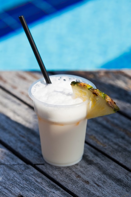 A pina colada cocktail with a pineapple slice