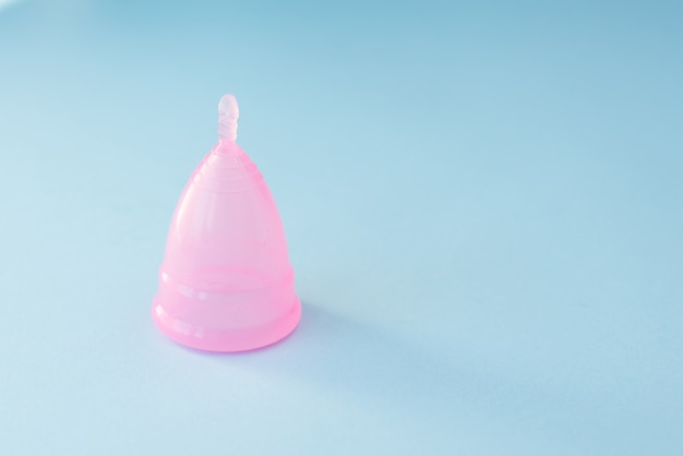 Pinc menstrual cup on blue background