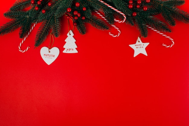 Pine branch and Christmas tree decorations on a red background