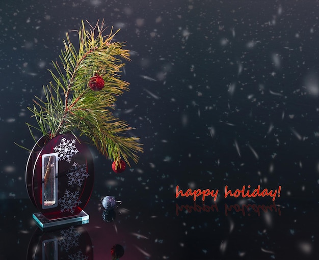 Pine branch with Christmas decorations on a dark background. Happy Holidays! Merry Christmas!