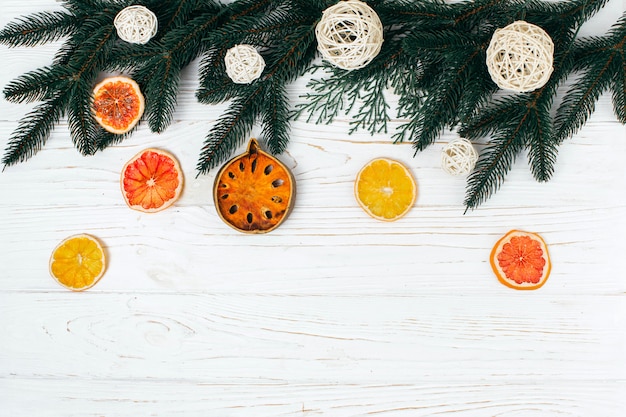 Pine branches and  dried fruits on the white board.