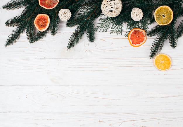 Pine branches and  dried fruits on the white board.