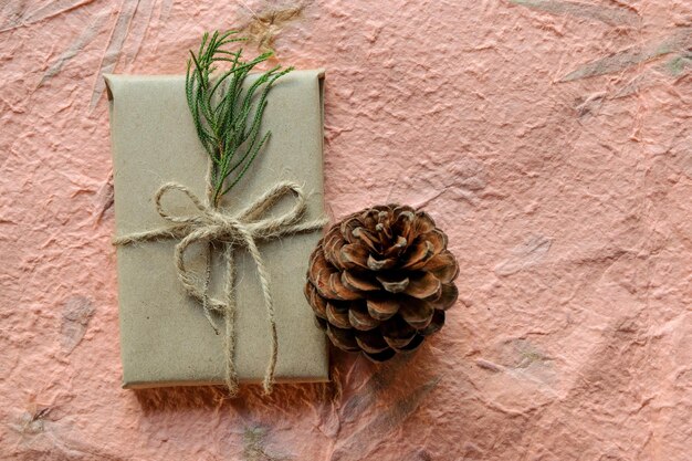 Photo pine cone and gift box against wall