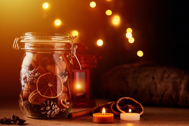 Pine cones in glass jar and fairy lights on a dark background.