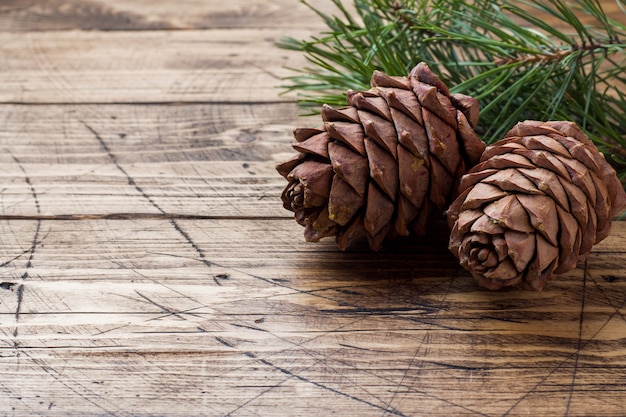 Pine cones and spruce branches on wooden table.