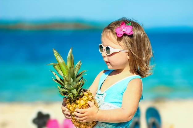 A Pineapple in the hands of a man by the sea in nature on a journey background