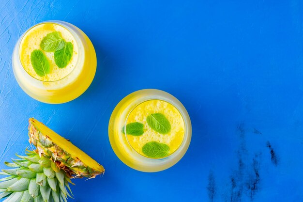 Pineapple juice on a blue background Juice for detox in the glass Pineapple smoothie