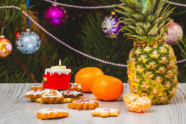 Pineapple mandarins and a fir tree with Christmas ornaments on the background