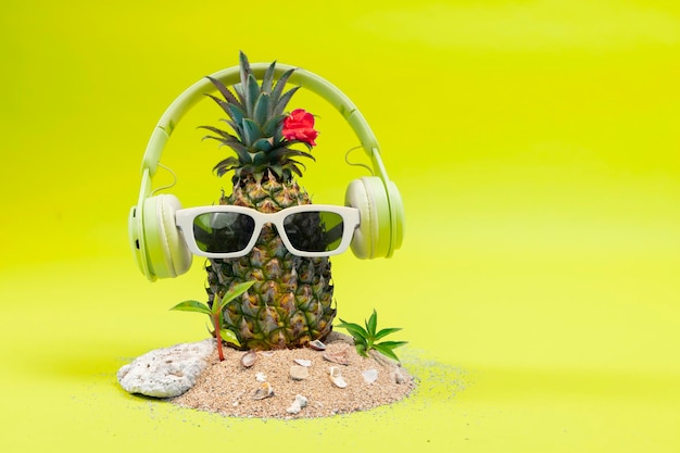 Pineapple in a sunglasses and headphone on white background