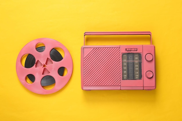 Pink Audio reel and cool radio receiver on yellow background Musical concept Top view Flat lay