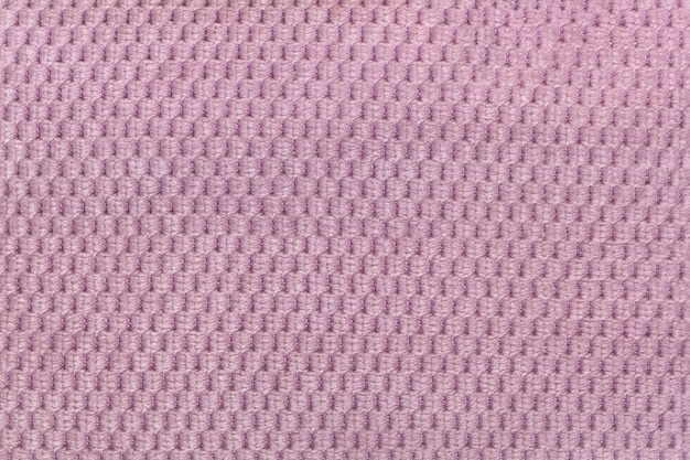 Pink background from soft fleecy fabric closeup. Texture of textile macro