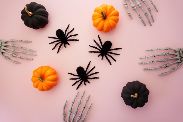 On a pink background, skeletal paws, pumpkins, spiders