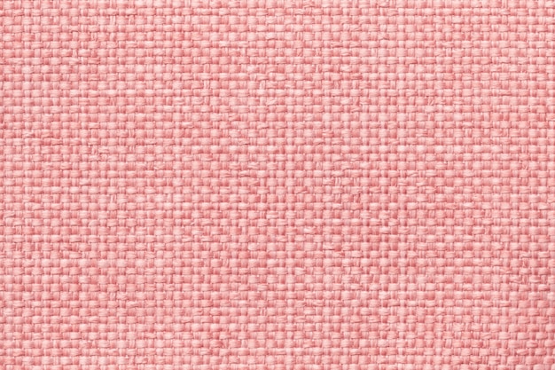 Pink background with braided checkered pattern, closeup. Texture of the weaving fabric, macro.