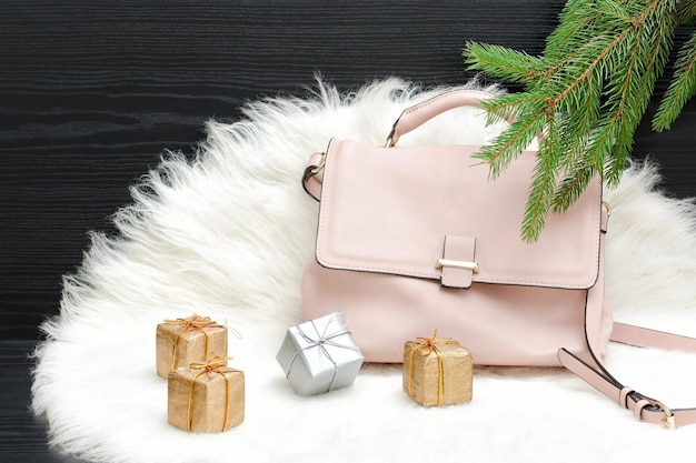 Pink bag gift boxes and spruce branch on white fur Fashionable concept