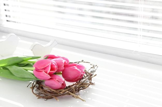 Pink beautiful tulips on windowsill with sunlight