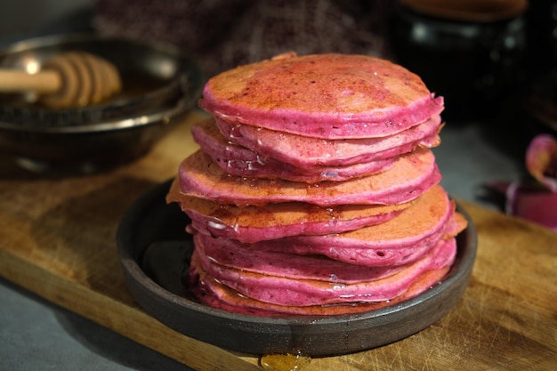 Pink beet pancakes poured honey