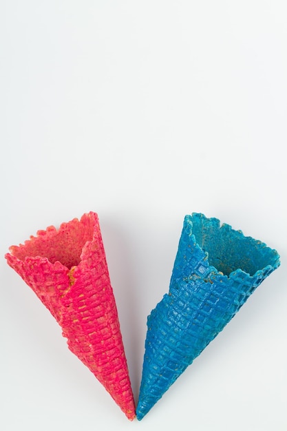 Pink and blue ice cream waffle cones on white background concept of difference between men and women