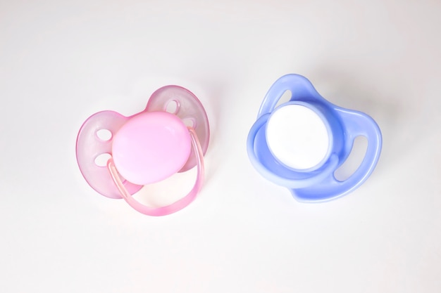 Pink and Blue Pacifiers on a white background. Two pacifiers close-up boy or girl isolated.