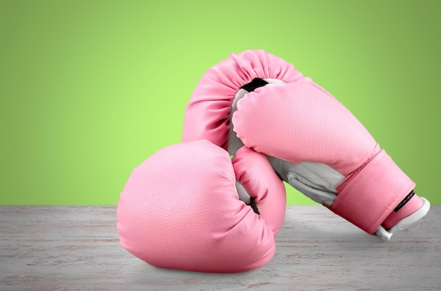 Pink boxing gloves on wooden background