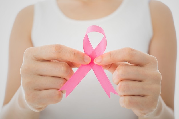 Pink Breast cancer awareness ribbon by woman who need to show healthcare concept.