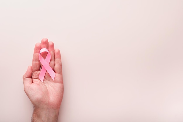 Pink Breast Cancer Awareness Ribbon Hands holding pink ribbon on backgrounds Breast cancer awareness and October Pink day world cancer day Top view Mock up