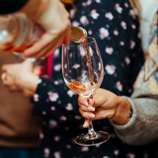 Pink champagne is poured into a glass to the visitor. 