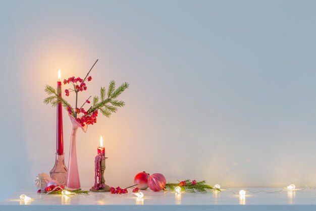 Pink christmas decor with burning candles in white interior