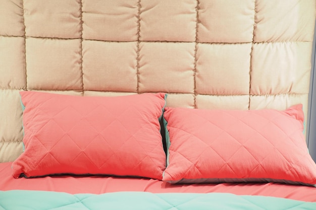 Pink color pillow lined up on bed