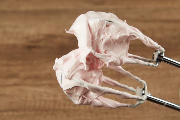 Pink colored merengue on a mixer close up