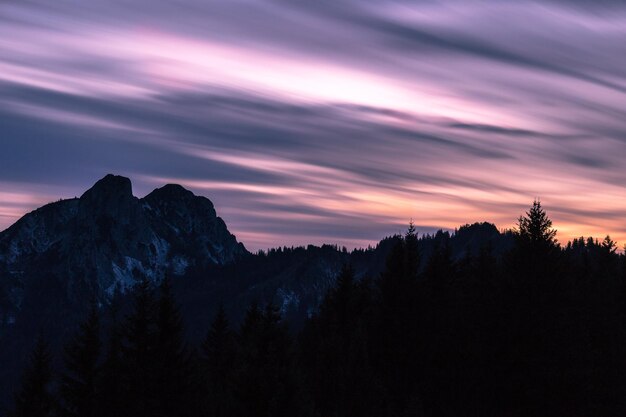 Pink colorful sky in mountains at dusk.