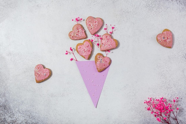 Pink cookies in form of heart in paper corn like bouquet of flowers valentine day or mother day conc