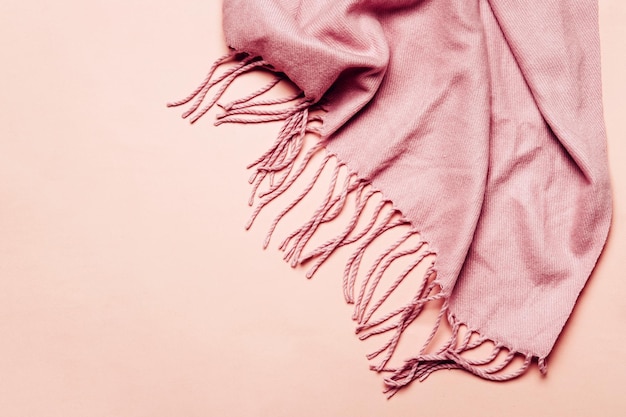 Pink cozy scarf with tassels on pastel background Minimal winter or autumn background for your design