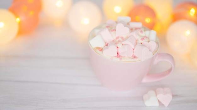 Pink cup with cocoa and heart-shaped marshmallows