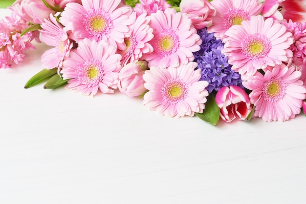 Pink daisy gerbera flowers on white table. Copy space. Holiday table.