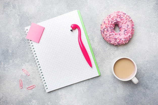 Pink doughnut and Cup of coffee Flamingo pen. Top view Flat lay.