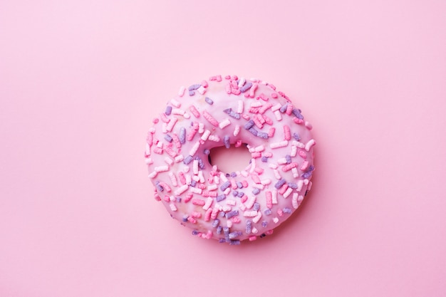 Pink doughnut on pink. Top view Flat lay.