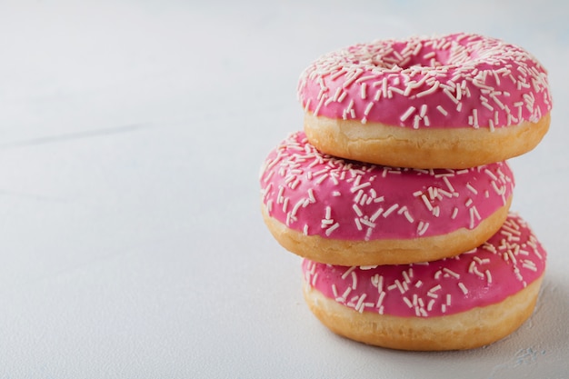 Pink doughnuts in icing sugar.