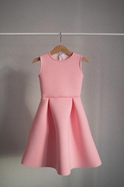 The pink dress is hanging on a hanger Children's clothing