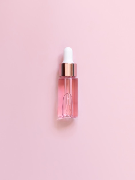 Pink Dropper Bottle on light pink top view Skincare beauty product