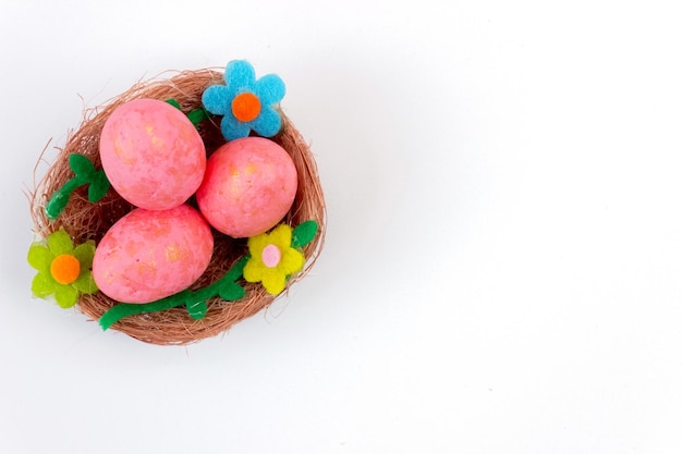 Pink Easter eggs in a nest on a white background Top view Copy space