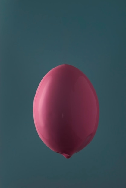 Pink egg paint on a blue background Easter minimalistic concept