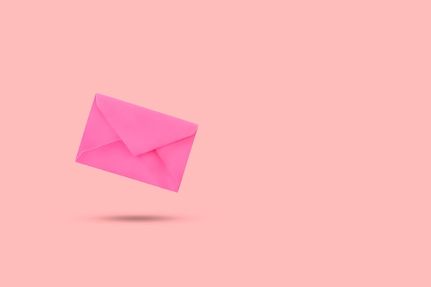 A pink envelope floating on a pink background with copy space