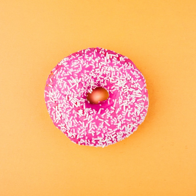 Pink glazed donut on orange