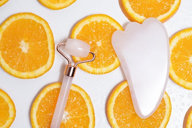 Pink gouache massagers lie on slices of oranges covered with water droplets