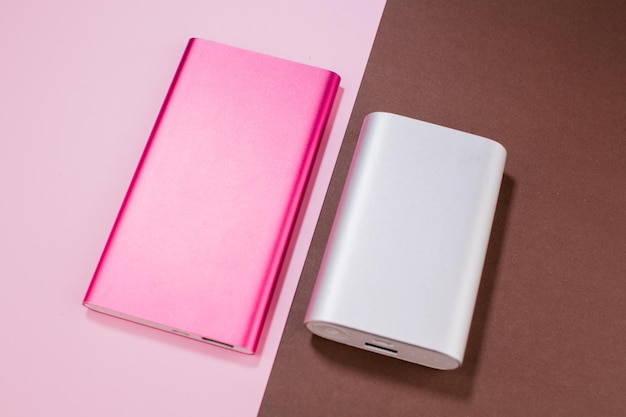 Pink and gray power bank on background