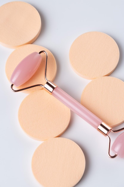 Pink Gua Sha massage tool on a white background closeup Rose Quartz jade roller