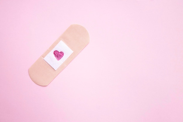 Pink heart on a bandage on a pink background