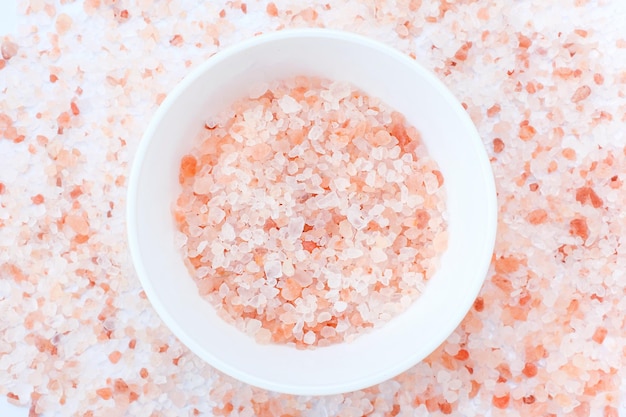 Pink Himalayan salt in a white bowl closeup top view