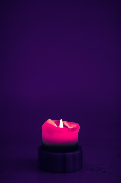 Pink holiday candle on purple background luxury branding design and decoration for Christmas New Years Eve and Valentines Day