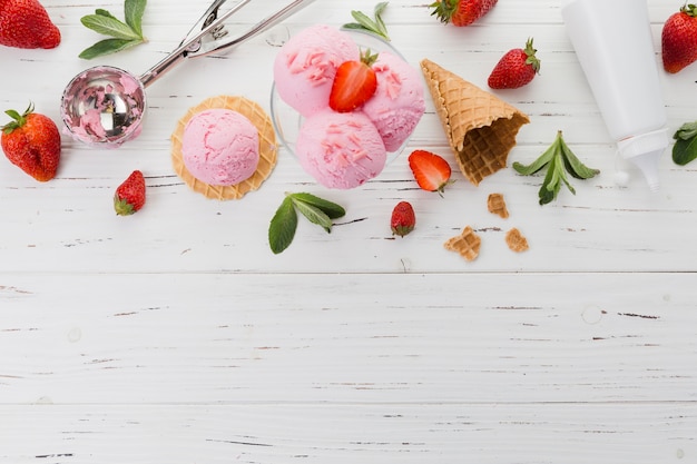 Pink ice cream with strawberries and scooper